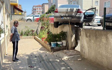 El freni çekilmeyen otomobil, hareket edip istinat duvarında asılı kaldı